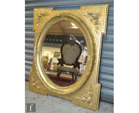 An oval wall mirror in a moulded leaf garland surround, within a stepped rectangular frame with floral corner mounts, 90cm x 