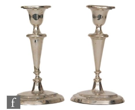 A pair of hallmarked silver candlesticks, reeded oval bases below knopped columns and conforming sconces each drilled for lam