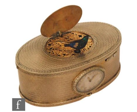 A 19th Century continental silver gilt singing bird box, the engine turned oval box with a watch to the front and slide butto