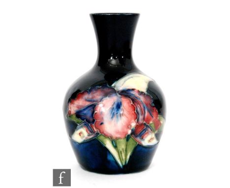 A small 1930s William Moorcroft pottery vase of baluster form with a flared collar neck, tube line decorated in the Frilled O