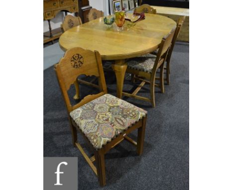 A 1920s light oak oval dining table on slender cabriole legs and pad feet with two extra leaves, extending to 178cm, and a se