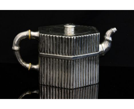 An Aesthetic Movement silver teapot, hexagonal section, each side with strapped dowel fence design, the handle and spout real