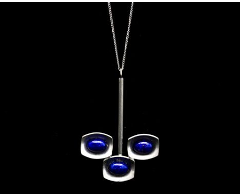 Jorgen Jensen, a Danish pewter and lapis lazuli effect pendant, the three concave cushioned tiles supported on a rod, set wit