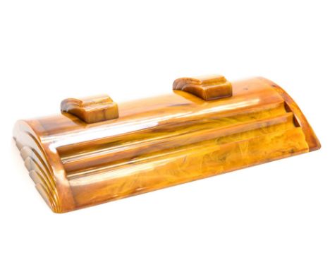 An Art Deco amber bakelite Carvacraft desk stand, segmental section with fan moulding to each end, the two sliding lids revea