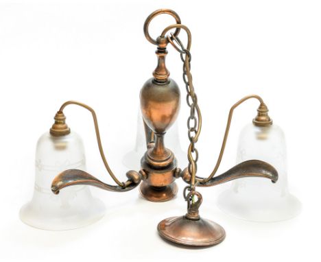 An Arts and Crafts coppered pendant ceiling light, three branches of naturalistic leaf form, supporting hanging glass shades