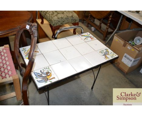 A metal based tile top table decorated with birds, some tiles AF