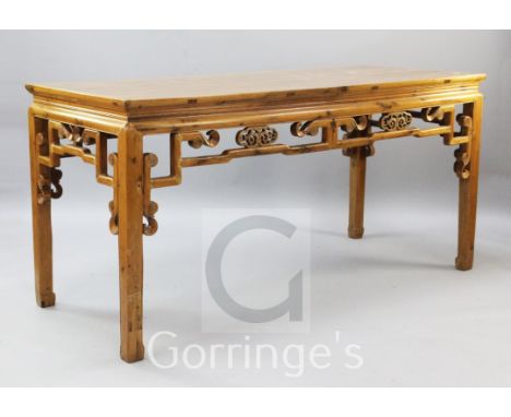 A Chinese golden wood altar type table, with scroll pierced frieze on squared legs, W.6ft 2in.