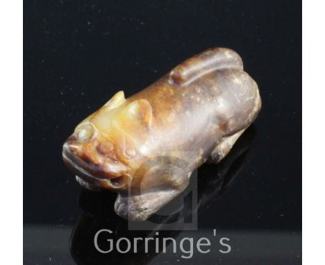 A Chinese celadon and brown jade figure of a recumbent lion-dog, Song dynasty or later, 5.7cm