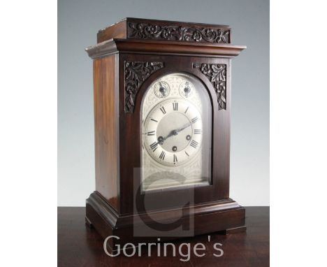 An early 20th century carved walnut mantel clock, with arched silvered dial and Junghans movement, 17in.