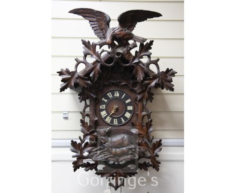 A Black Forest carved cuckoo clock with eagle surmount. 35in.