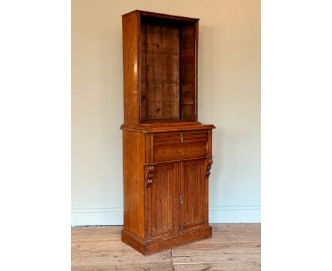 An early 20th century oak secretaire bookcase of small proportions - the open bookcase top (lacks shelves), over an ogee secr