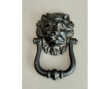 An antique cast iron lion mask door knocker - probably 19th century, later black painted (traces of earlier blue and yellow p