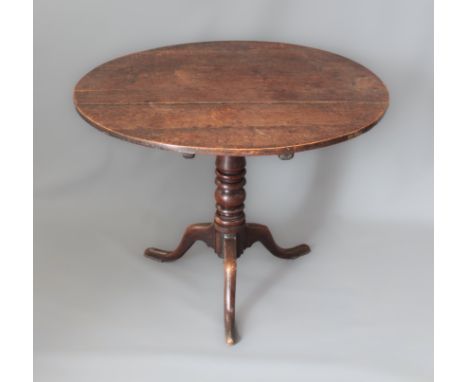 A George III circular oak tilt-top tripod table - with a bobbin-turned column and swept supports with slender pad feet, 88cm 