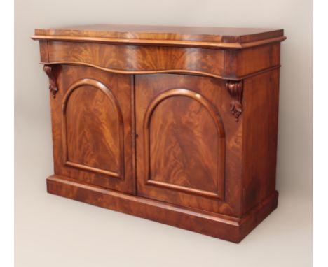 A Victorian serpentine-fronted mahogany chiffonier - the edge of the slightly overhanging top with cockbeading, the long draw