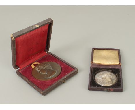 A cased French bronze sporting medal, c.1900 and a c.1900 gilded metal cast of an ancient Greek coin in original glass covere