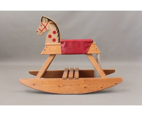 A vintage 1970s painted plywood and pine rocking horse - with red vinyl seat. (LWH 90 x 39 x 67cm)