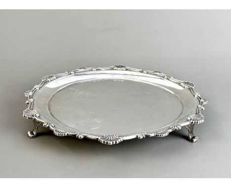 A silver salver by Hunt & Roskell - London 1923, scalloped edge and three scroll feet, the underside stamped 'Hunt & Roskell 