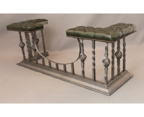 A modern wrought iron and leather club fender - the buttoned, green leather seats raised on twist supports, on an ogee moulde