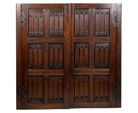 A pair of antique oak linen-fold paneled cupboard doors Each door with six panels, of pegged construction, and with iron stra