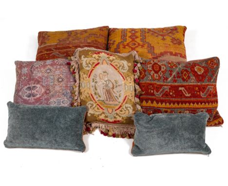 A group of Antique Turkish Oushak carpet fragments mounted as cushions With needlework coverings in reds and blues.The larges