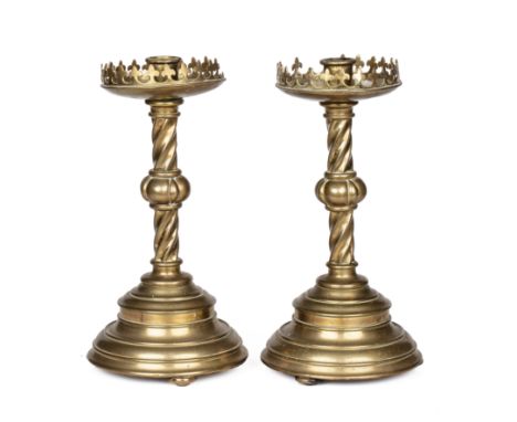 A pair of 19th century brass candlesticks The drip trays with a fleur-de-lys shaped gallery, on twisting supports with spread