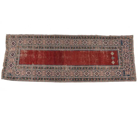 An early 20th-century woollen hand-woven Caucasian runner The central red ground with three small geometric medallions at one