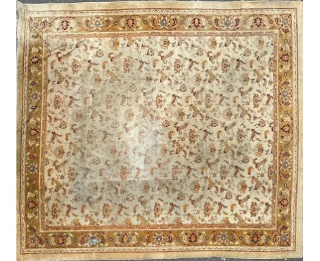 An Antique Indian Amritsar carpet With a cream ground, yellow border and stylised foliate decoration.500cm x 415cmQty: 1The E