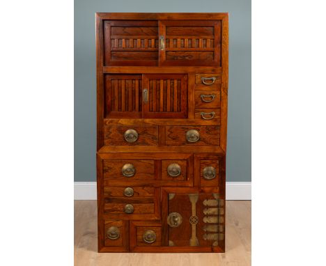 A Japanese Step Tansu, elmwood, two-tier cabinet With an arrangement of twelve drawers, brass mounts and handles, and three c
