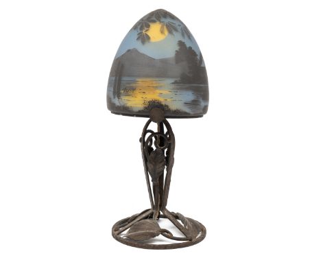 A Deveau cameo glass lamp c.1900 The shade depicting moonlit scenes of trees and mountains and signed 'Deveau', on a foliate 