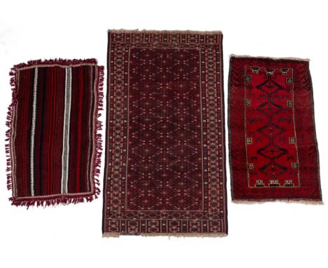 A group of three rugs To consist of a Caucasian flat-weave rug, the red ground with a repeating geometric pattern and a guard