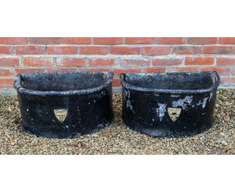 A pair of lead planters Each black painted 'D' shaped planter with an emblem to the front for The Golden Cross, Oxford63cm wi