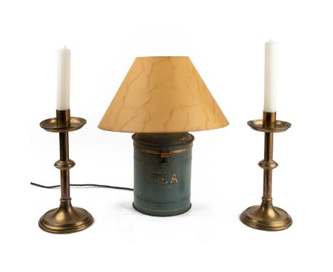 A pair of brass candlesticks together with a table lamp converted from a tea can The candlesticks of turned form on circular 