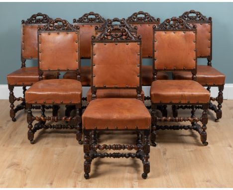 A set of eight Jacobean style oak dining chairs With carved acanthus leaf top rails, tan leather upholstery to the backs and 