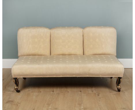 A 19th century cream upholstered sofa With four black and parcel gilt carved short cabriole legs terminating in brass castors