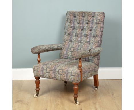 A Victorian open armchair With turned walnut supports to the arms, the turned legs to the front terminating in brass feet and