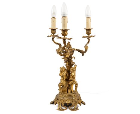 A gilt metal three-branch electrolysed candelabra With twisting foliate branches, a foliate support surrounded by three danci