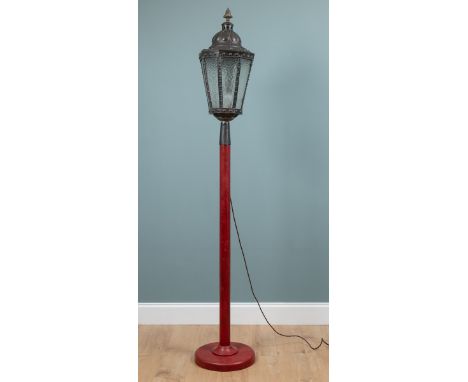 A copper street lantern converted for use as a standard lamp On a red turned support and a spreading base.230cm highQty: 1In 