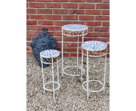 A nest of three circular garden or conservatory tables together with a cast iron shield-shaped wall plaque The blue and white