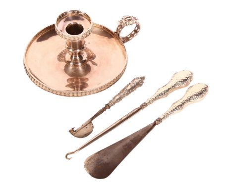 A silver-handled button hook, shoe horn, and another, and a silver plated chamber stick 