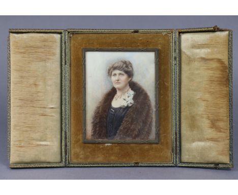 An early 20th century portrait miniature of a lady wearing fur stole, 4¾” x 3¾”, in brass frame &amp; folding case on easel s