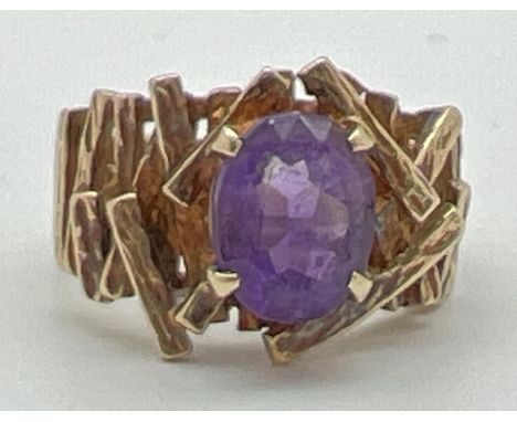 A chunky vintage 9ct yellow gold dress ring set with central oval cut amethyst. With textured pierced detail to shoulders. Fu