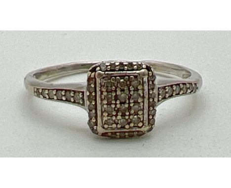 A 9ct white gold and diamond set dress ring. Square shaped mount set with 35 small round cut diamonds (3 stones missing) with