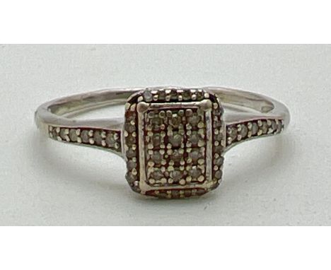 A 9ct white gold and diamond set dress ring. Square shaped mount set with 35 small round cut diamonds (3 stones missing) with