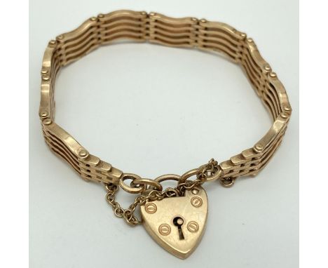 A 9ct yellow gold 5 bar gate bracelet with heart shaped padlock clasp &amp; safety chain. Stamped 9 &amp; 375 to back of padl