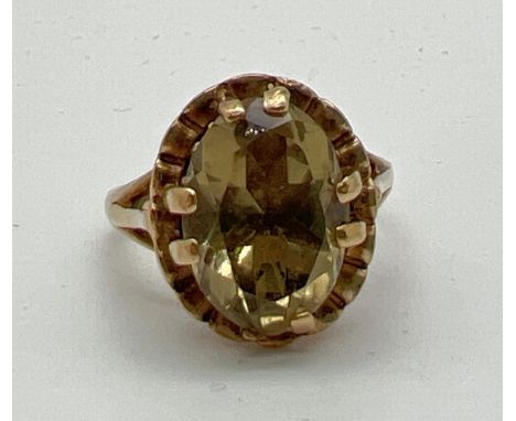 A vintage 9ct gold dress ring set with a large oval cut green citrine stone. High shoulder with a pierced work decorative mou