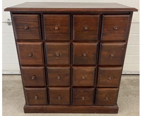 A vintage dark wood 16 drawer chest. With square shaped drawers and wooden knob handles. Approx. 85cm tall x 78.5cm wide x 40