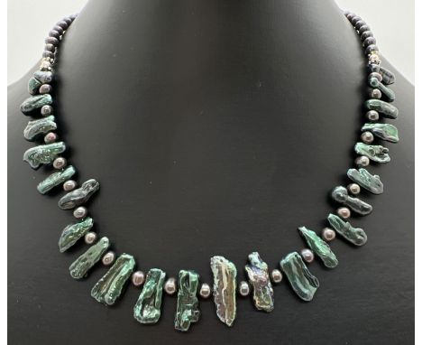 A 16" dark green lustre dyed Heishi pearl necklace with silver tone T bar clasp. Retired jewellery makers stock. 