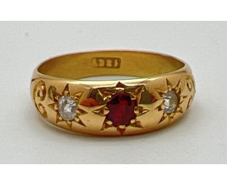 An 18ct gold gypsy style ring set with a central garnet and 2 diamonds. Stones set with claws and in a star shaped engraved s