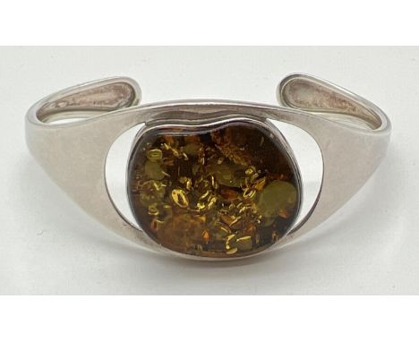 A modern design cuff bangle set with a large piece of green Baltic amber. Hallmarks to back of bangle. Total weight approx. 1