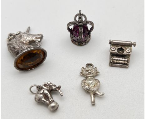 5 assorted vintage white metal charms, all unmarked. To include a stone set coronation crown, an amber coloured stone set uni